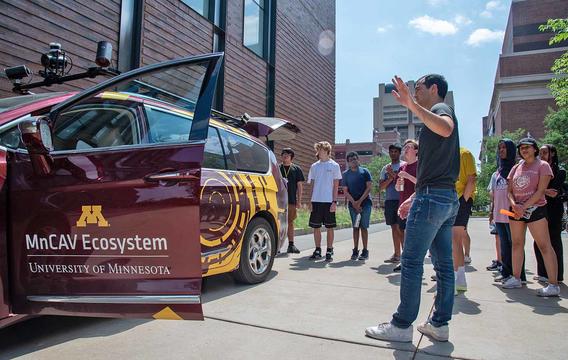 CAV campers gathers outside the research vehicle on campus